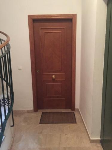 a wooden door in a room with a staircase at Medina Azahara in El Higuerón