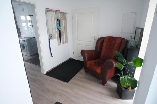 a living room with a red chair and a plant at Ferienwohnung Lerchenstraße in Schwerin