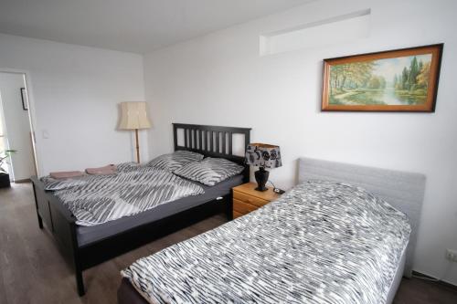 a bedroom with two beds and a picture on the wall at Ferienwohnung Lerchenstraße in Schwerin
