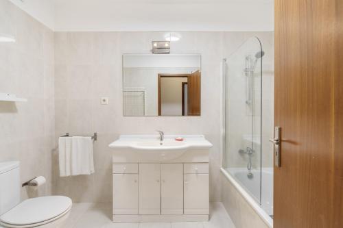 a bathroom with a sink and a toilet and a mirror at Lodge confortável na Sé - Minho's Guest in Braga