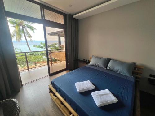 ein Schlafzimmer mit einem blauen Bett und Meerblick in der Unterkunft Seajour Beach Resort in Ginatilan