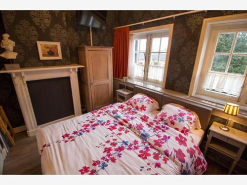 a bedroom with a bed with flowers on it at B&B l'Heritage in Lo-Reninge