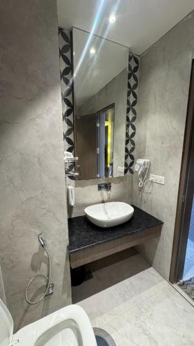 a bathroom with a sink and a mirror at Hotel The Grand Mirage in Bathinda