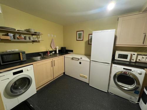 a kitchen with a refrigerator and a washer and dryer at Riverview Colchester in Colchester