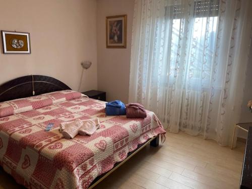 a bedroom with a bed with a red blanket and a window at La Terasa del Cichino in Roe