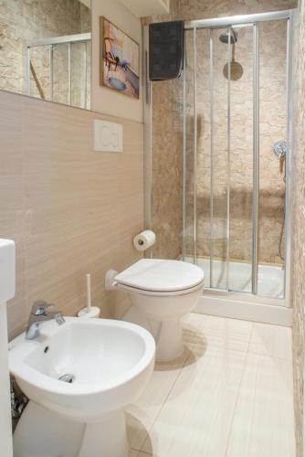a bathroom with a toilet and a sink and a shower at Le Sable Fin Beach House in Viareggio