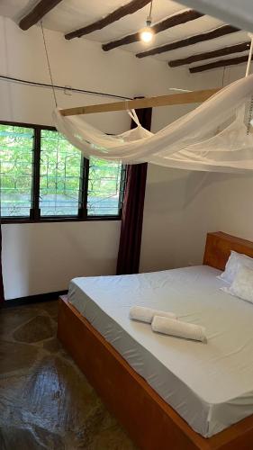 a bedroom with a bed with two white towels on it at 2 Bedroom serene cottage in Ukunda Airport