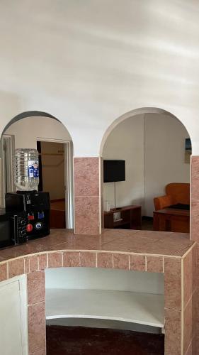 a living room with two arches and a room with a couch at 2 Bedroom serene cottage in Ukunda Airport