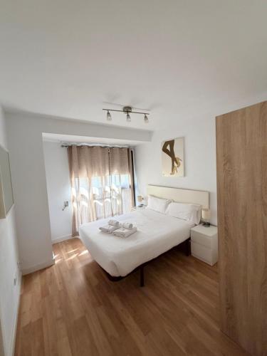 a bedroom with a white bed and a wooden floor at Zerka Centro in Valencia