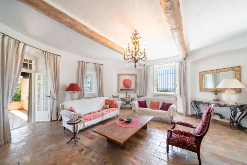 a living room with a couch and a table at Villa au calme jardin piscine proche mer et centre ville in Vallauris