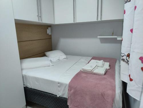 a small room with a bed with towels on it at Hospedaria AlpenGlück in Treze Tílias