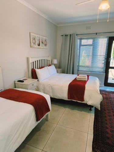 a hotel room with two beds and a window at Croeso Guest House in Langebaan