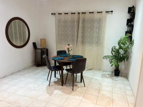una sala da pranzo con tavolo, sedie e uno specchio di Chambre Standard a Dakar