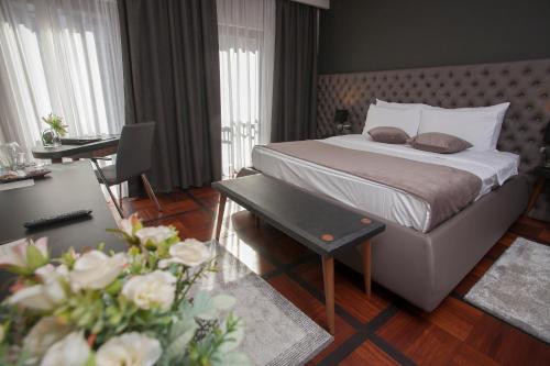 a hotel room with a bed and a desk and a room at Solun Hotel & SPA in Skopje