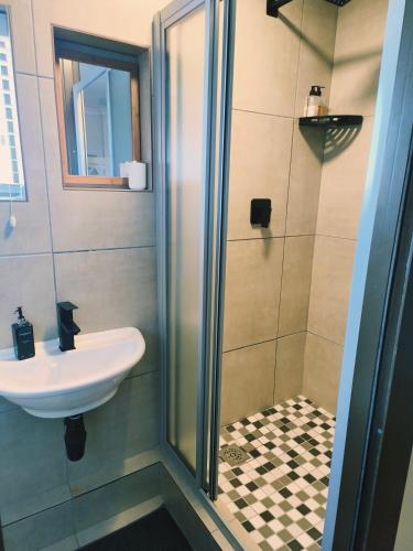 a bathroom with a shower and a sink at Croeso Guest House in Langebaan