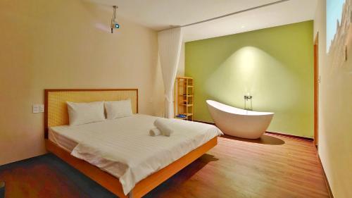 a bedroom with a bed and a bath tub at DEE Homestay in Hue
