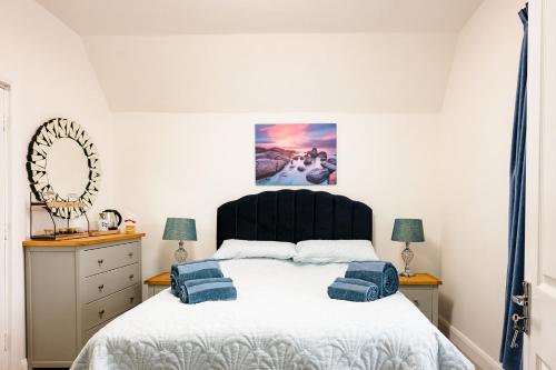 a bedroom with a bed with blue pillows on it at Rosie's Rest in Hunstanton