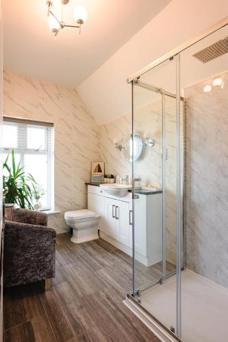 a bathroom with a glass shower and a toilet at Rosie's Rest in Hunstanton