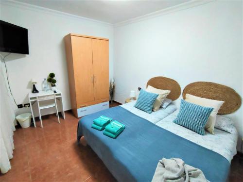 a bedroom with a blue bed and a desk at Rincón de Joel Habitación con baño privado in La Orotava
