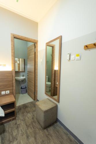 a bathroom with a sink and a mirror and a stool at Front One Budget Malioboro Jogja in Yogyakarta