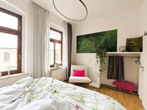a white bedroom with a bed and a pink pillow at City Pension in Reichenbach im Vogtland