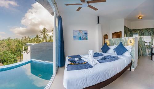 a bedroom with a large bed next to a swimming pool at Aura Koh Tao in Ko Tao