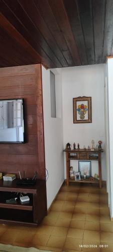 a living room with a tv on a wall at Nossa casa in Petrópolis