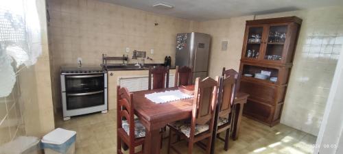 a kitchen with a wooden table with chairs and a refrigerator at Nossa casa in Petrópolis
