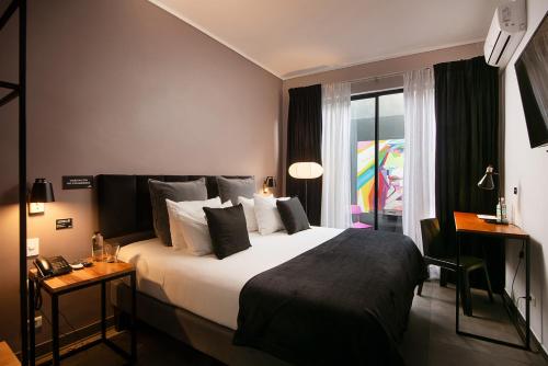 a hotel room with a large bed and a window at The PopCity Hotel in Santiago