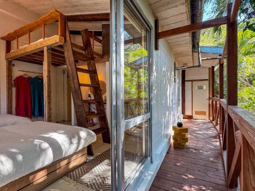a bedroom with a bunk bed and a balcony at サ郷 kakeRu 新旧アースバッグサウナ付 in Onna