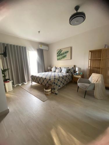 a bedroom with a bed and a chair and a window at Apartamento Vacacional Coral Azul - SBH in Bayahibe