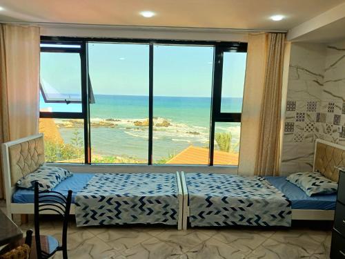 a bedroom with a window with a view of the ocean at Appart hôtel palais de mer in Jijel