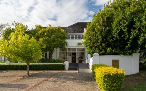 a white house with trees in front of it at Wild Mushroom Country House in Stellenbosch