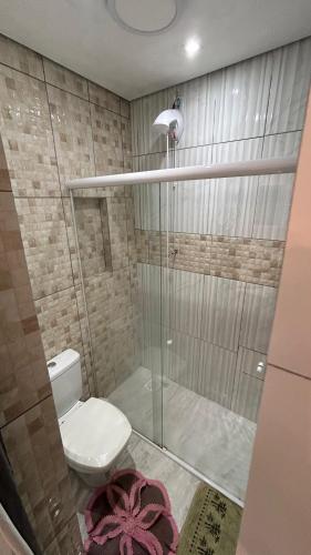 a bathroom with a toilet and a glass shower at Suíte por do sol 3 casa compartilhada in Xangri-lá