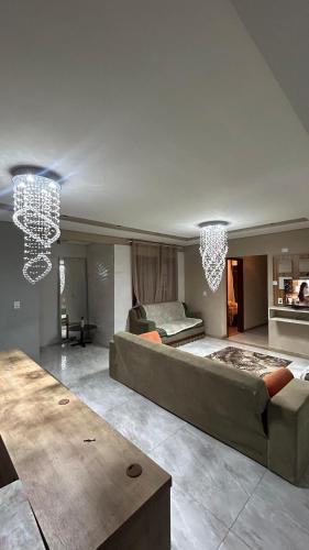 a large living room with a large bed and chandeliers at Suíte por do sol 3 casa compartilhada in Xangri-lá