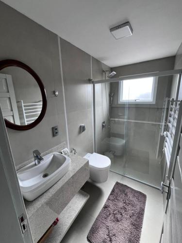 a bathroom with a sink and a toilet and a mirror at Garibaldi Guest House in Garibaldi