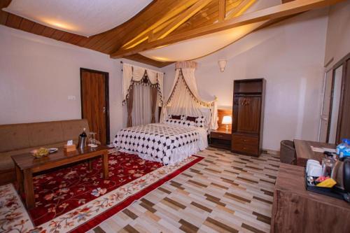 a bedroom with a bed and a living room at RJ Hotel Pokhara in Pokhara
