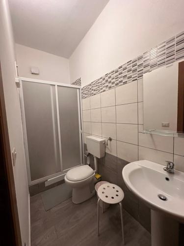 a white bathroom with a toilet and a sink at Palazzo montagna in Grotte