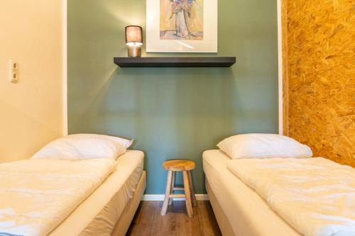 a room with two beds and a stool in it at Studio Kweepeer in Ruinerwold