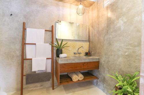 a bathroom with a sink and a mirror at Sampian Cottages Bingin in Uluwatu
