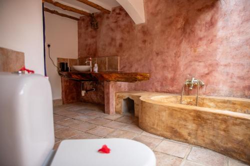 a bathroom with a wooden tub and a sink at VeriDiana Hotel Zanzibar in Dimbani
