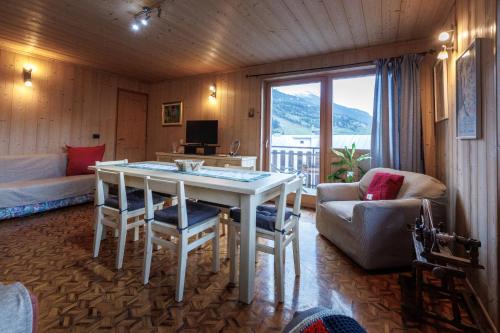 a living room with a table and a couch at Chalet Beppe in Bormio