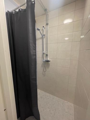 a shower with a black shower curtain in a bathroom at Laplanders room 2 in Kiruna