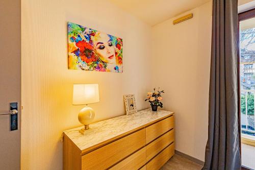 a bedroom with a dresser and a painting on the wall at Le 28 C chouette - Spacieux - Box privé - Ascenseur - Centre in Dijon