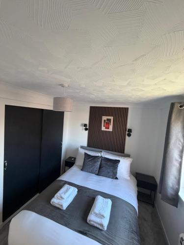 a bedroom with a large white bed with two pillows at Nessy5 Apartment in Inverness