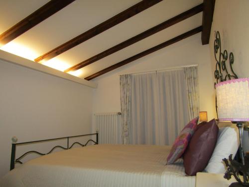 1 dormitorio con 1 cama grande y techo de madera en Il Borghetto, en Chiavenna