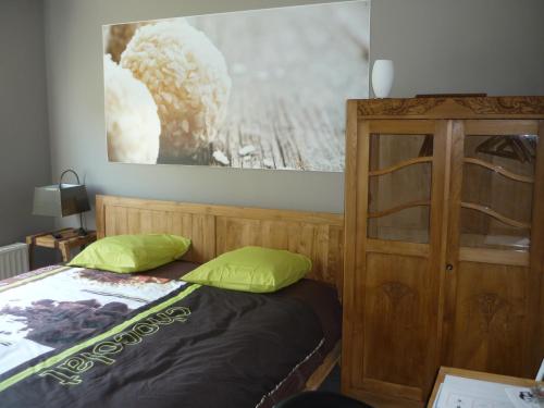 a bedroom with a bed and a wooden cabinet at B&B Wiezebed in Wieze