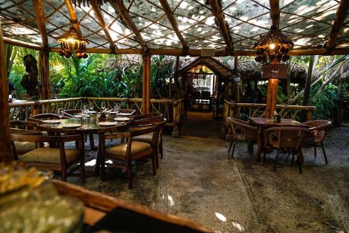 a restaurant with wooden tables and chairs and a ceiling at Departamento Mayan Lakes T9 - Albercas, club de playa, tenis, pádel y más in Acapulco