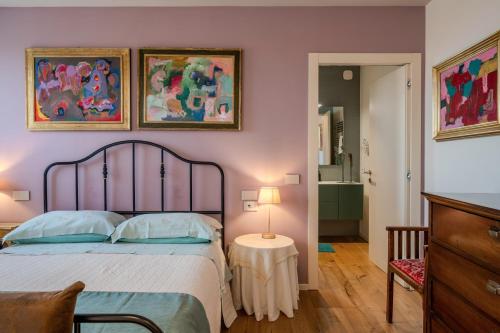 a bedroom with a bed and two paintings on the wall at GIULIVETO Bed and Breakfast in Foligno