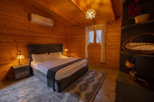 a bedroom with a bed in a wooden cabin at اكواخ لوسو الريفيه in Ḩayy al Ḩamdānīyah